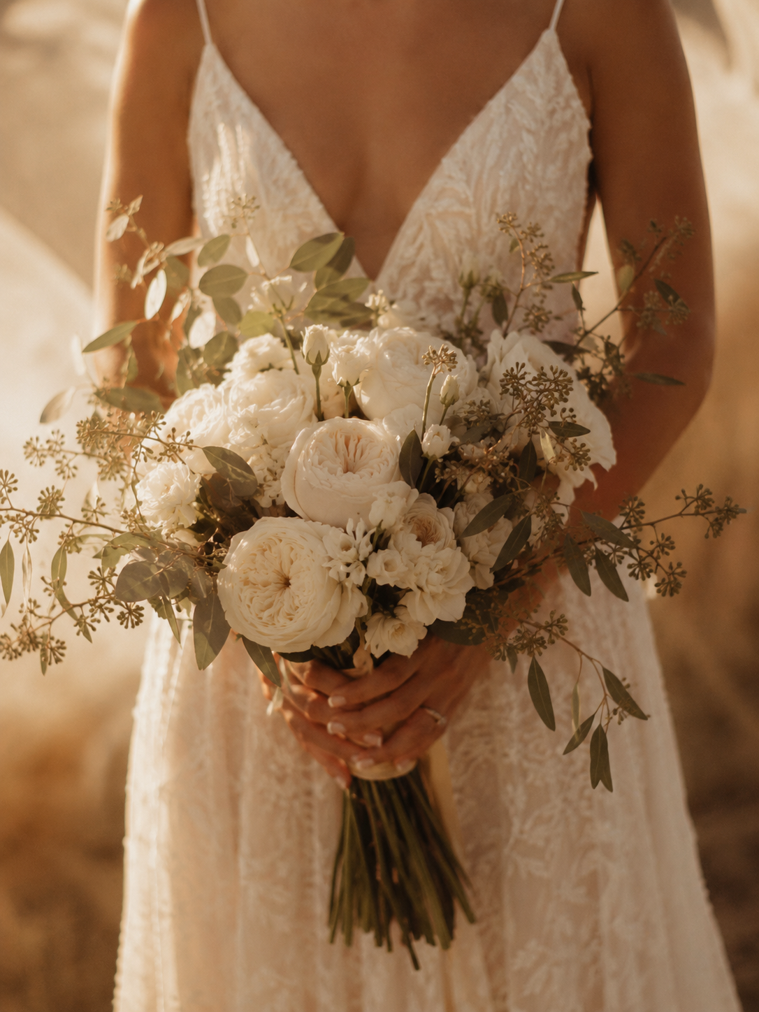 Novia sosteniendo su ramo de rosas blancas