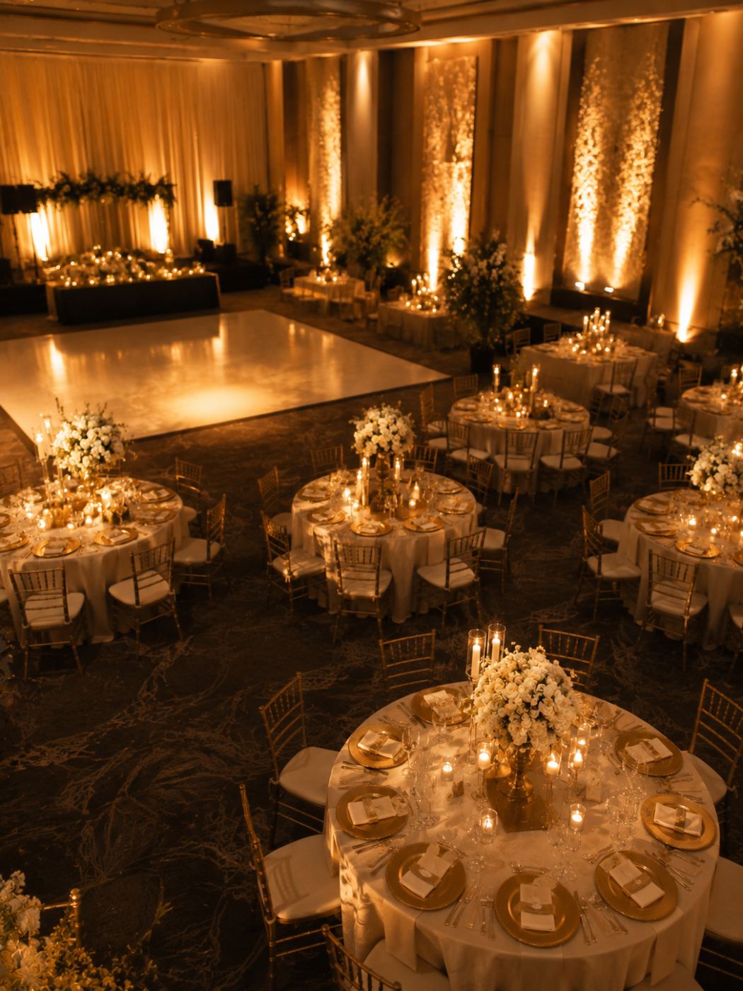 Salón completo montado con arco de globos dorados antes de la entrada de los invitados